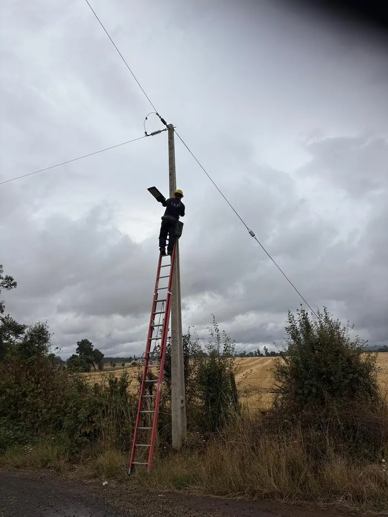 Técnico de G&R subiendo una escalera apoyada en un poste