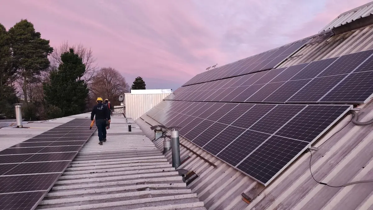 Técnico de G&R caminando sobre un techo con paneles solares instalados